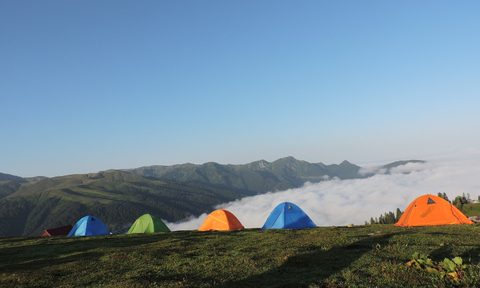Tent campers at a campsite on a mountain ridge.