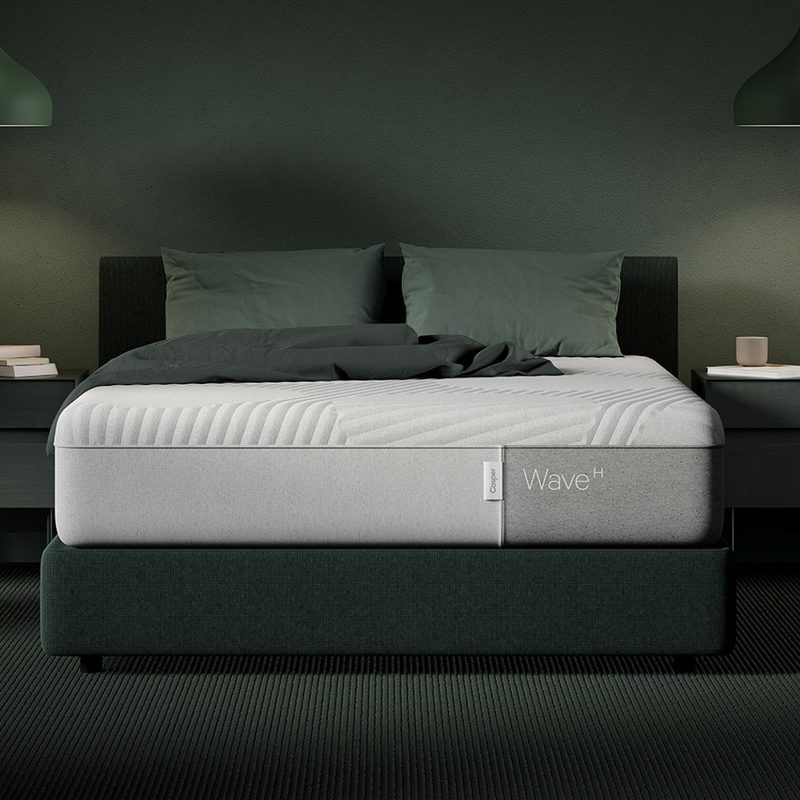 A Casper Wave Hybrid mattress sits in a green room.