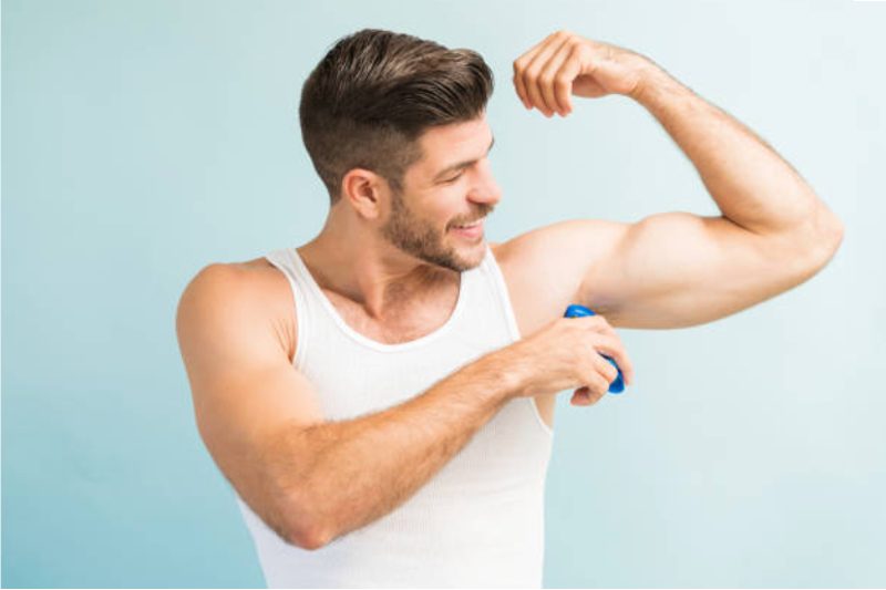 Man applying deodorant.