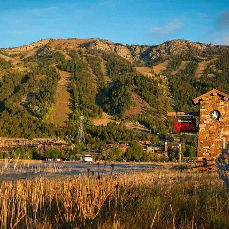 Looking at the exterior of the Hotel Terra Jackson Hole with the Jackson Hole resort in the background