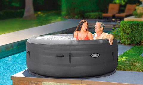 A couple relaxes in their Intex SimpleSpa portable inflatable hot tub.
