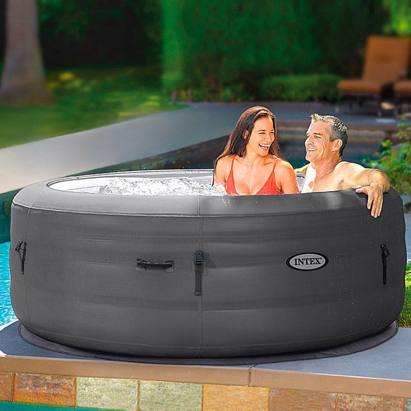 A couple relaxes in their Intex SimpleSpa portable inflatable hot tub.