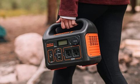 Person holding Jackery Explorer 300 in the woods.