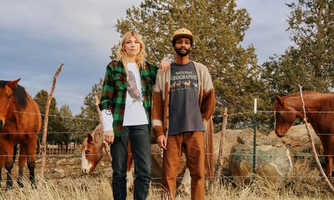 Models wear National Geographic and Parks Project T-shirts while standing in front of horses.