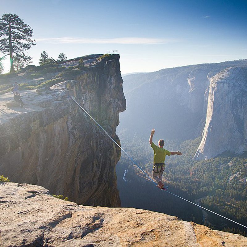 A daredevil walks across a tightrope to Taft Point, overlooking Half Dome and Liberty Cap in California's Yosemite National Park.
