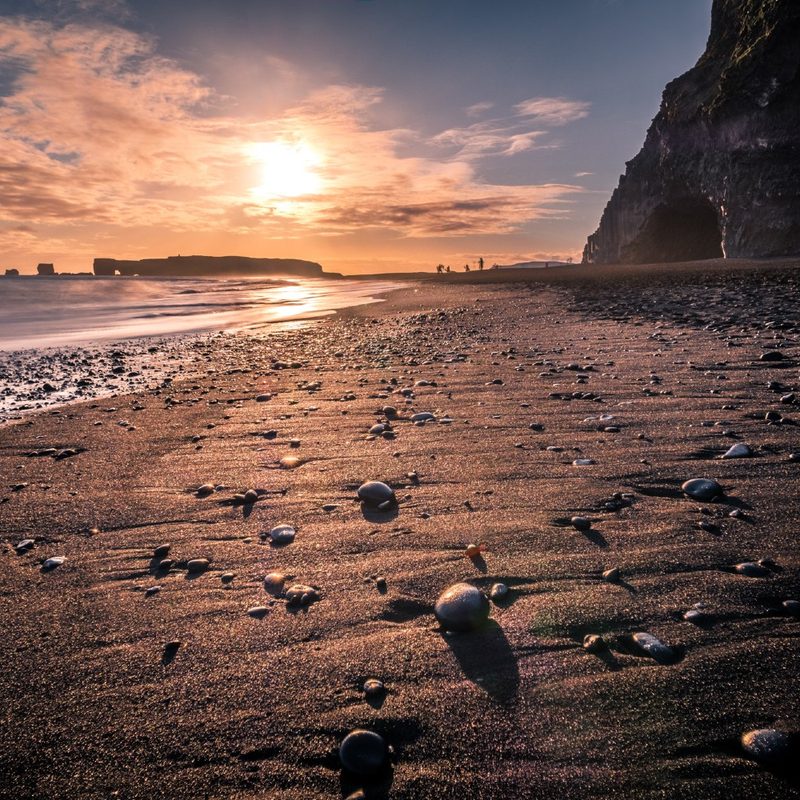 The sun shining on the Reynisfjara Black Sand Beach in Iceland.