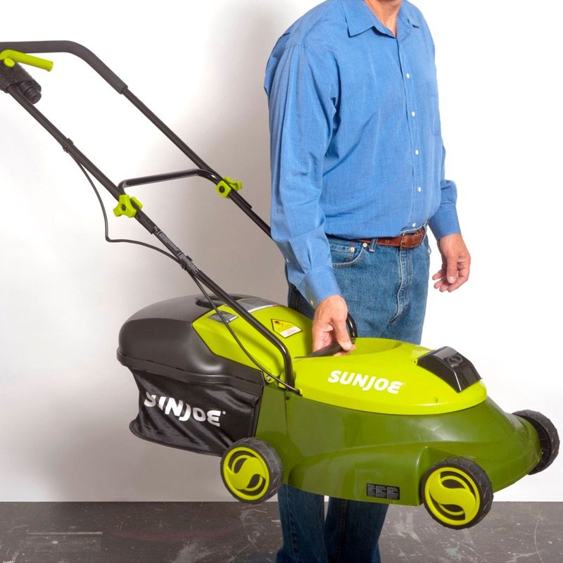 A man illustrates the compact benefits of the Sun Joe cordless lawn mower.