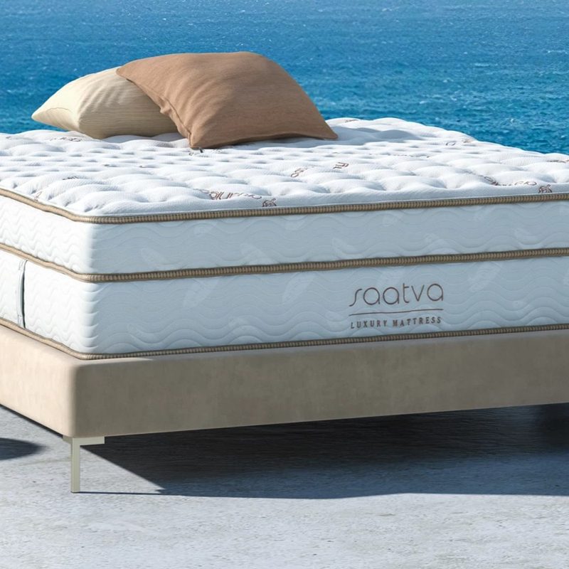 A Saatva Classic mattress lies on a patio facing the ocean.