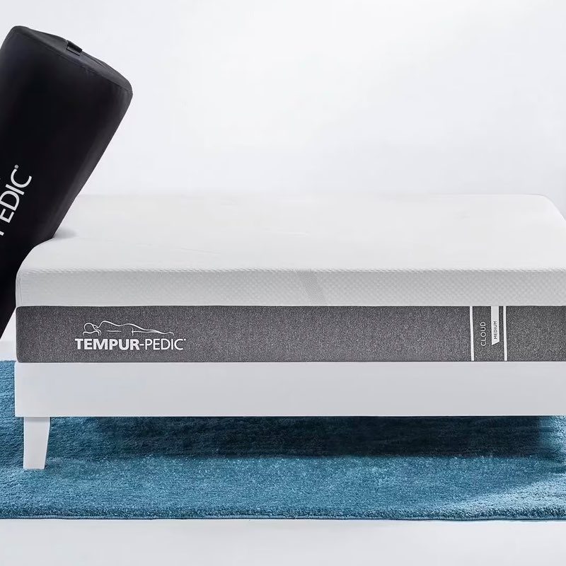 The Tempur-Pedic Cloud mattress on a bed frame in a bedroom.