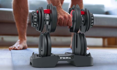 A man lifts the FitRx SmartBell adjustable dumbbell.