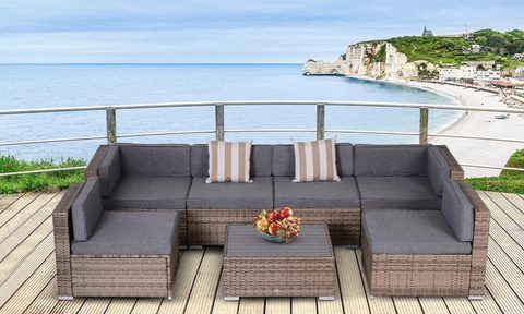 Merton sectional seating group with cushions on a wooden deck overlooking water.