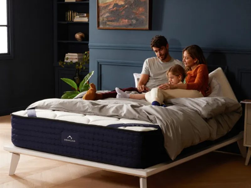 A family of three people reading on a DreamCloud mattress.