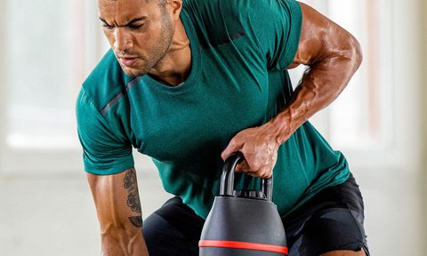 A man works out with a Bowflex SelectTech 840 Adjustable Kettlebell.