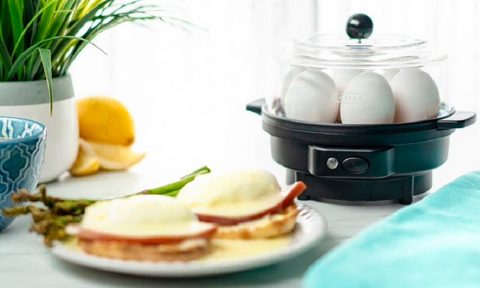 The Bella egg cooker with a plate of eggs benedict.