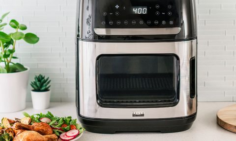 Bella Pro 12.6-quart Pro digital air fryer oven with a prepared meal of chicken drumsticks and salad.