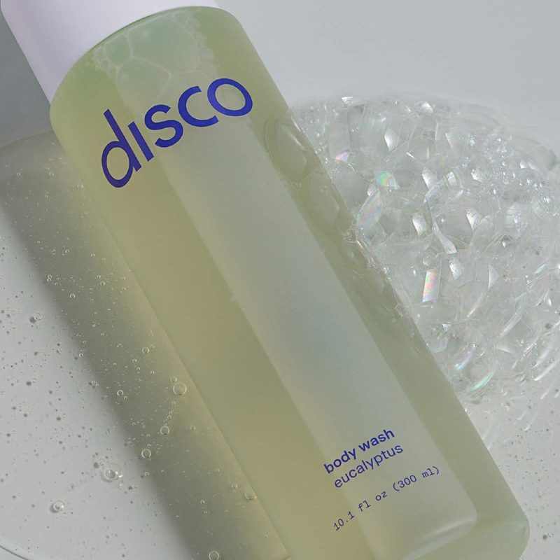 A bottle of Disco Invigorating Body Wash in a bathroom.