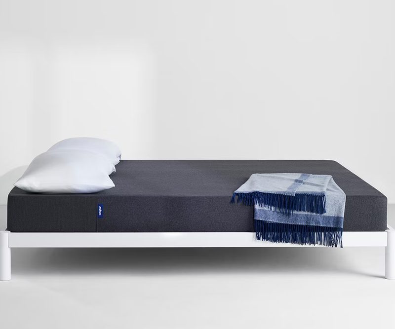 The Casper Snug memory foam mattress on a frame.