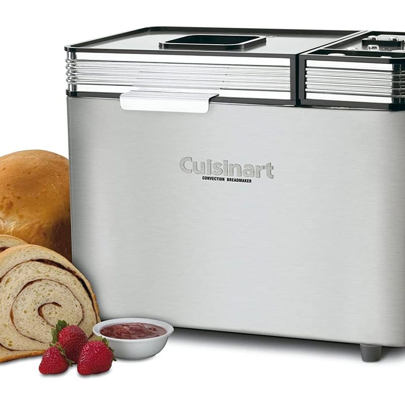 The Cusinart CBK-200 convection bread maker is sits next to a loaf of bread and strawberries.