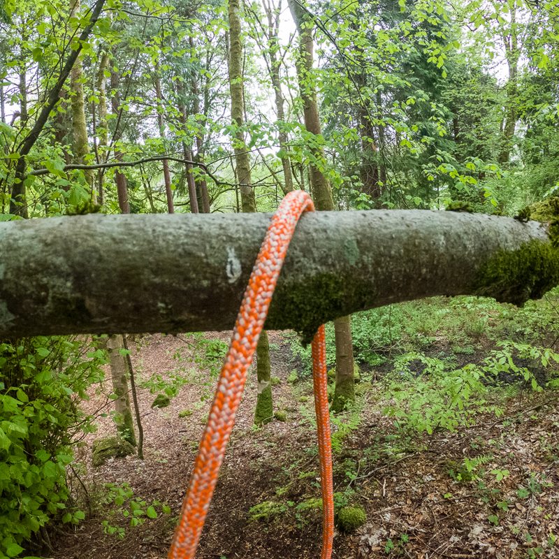 Step one of tying a clove hitch, a rope draped over a branch