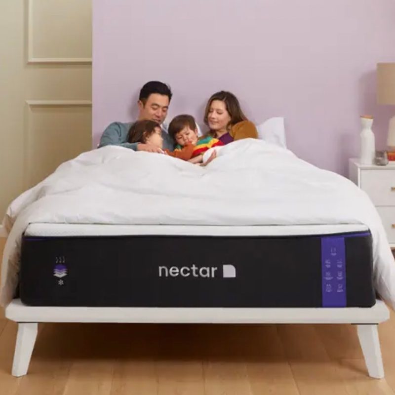 Family snuggled in a nectar bed in a bright bedroom.