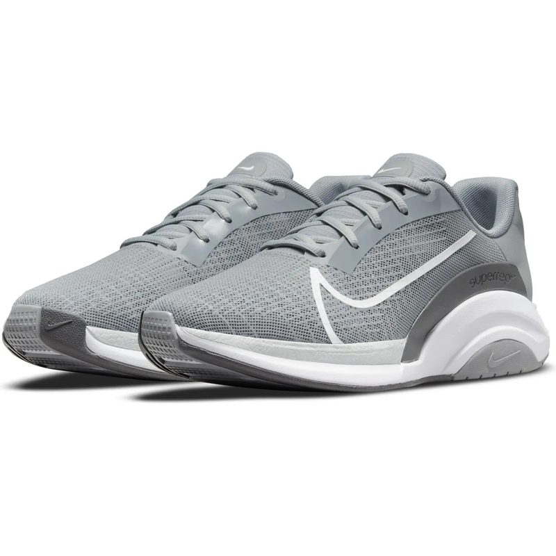 A pair of gray Nike sneakers sit against a white background.