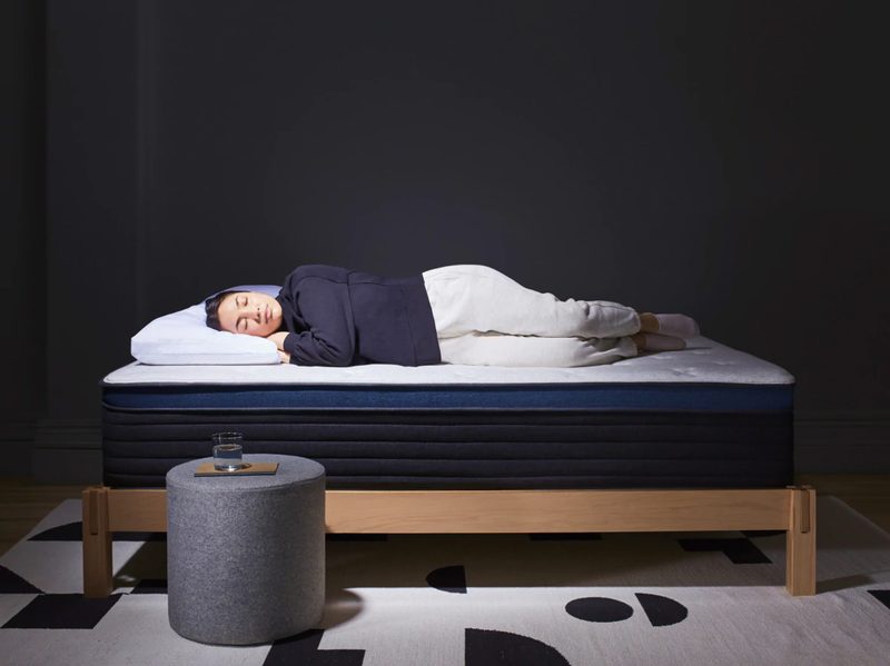 Person sleeping on a HELIX MIDNIGHT LUXE mattress with minimal covering.