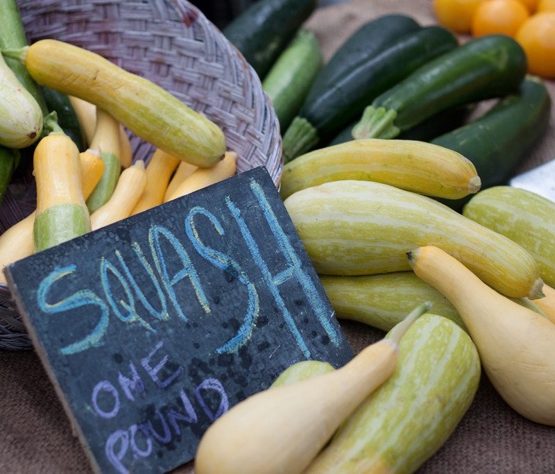 Squash on a table at a market with sign