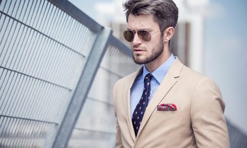 Man in a tan suit on bridge