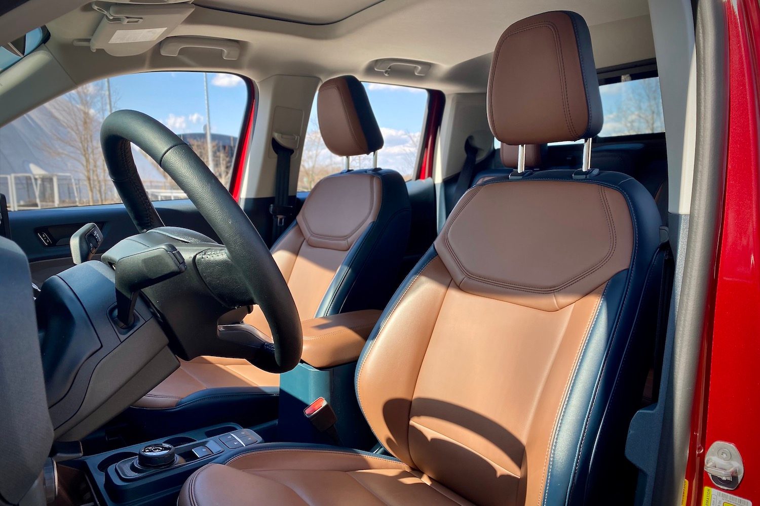 2022 Ford Maverick front seats from driver's side outside the vehicle with blue skies in the back.