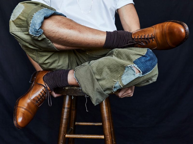 Allen Edmonds model on bench wearing shoes.