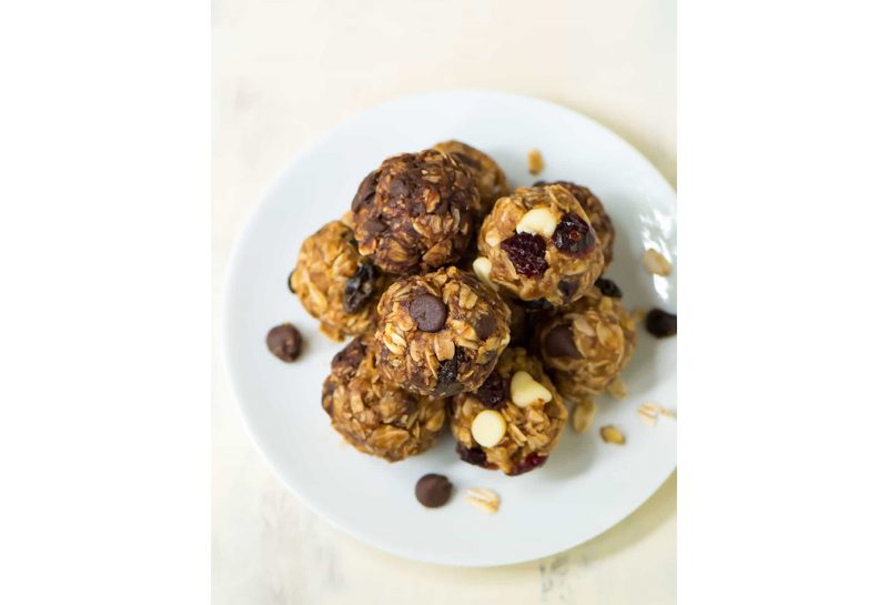 A top down view of a plate of stacked oat and chocolate chip energy balls.