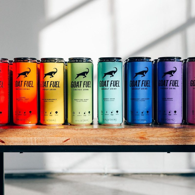 Various cans of G.O.A.T Fuel resting on a bench