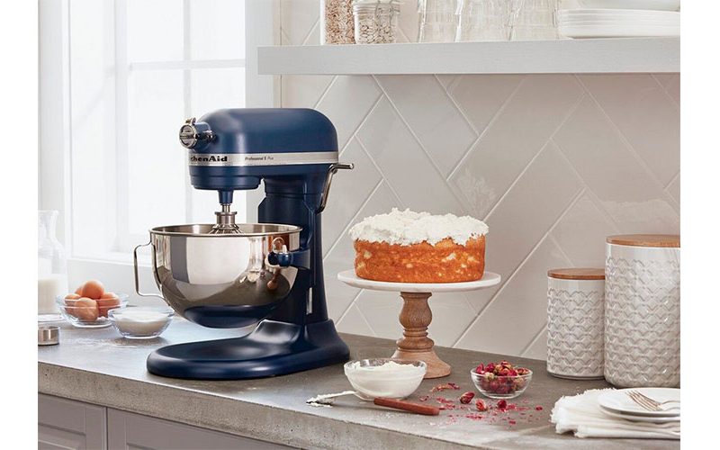 KitchenAid Pro 5 Plus 5 Quart Bowl-Lift Stand Mixer placed on a kitchen countertop next to a baked cake.