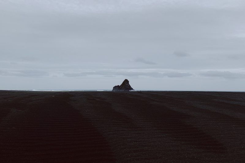 Long stretch of black sand at New Zealand's Karekare Beach.
