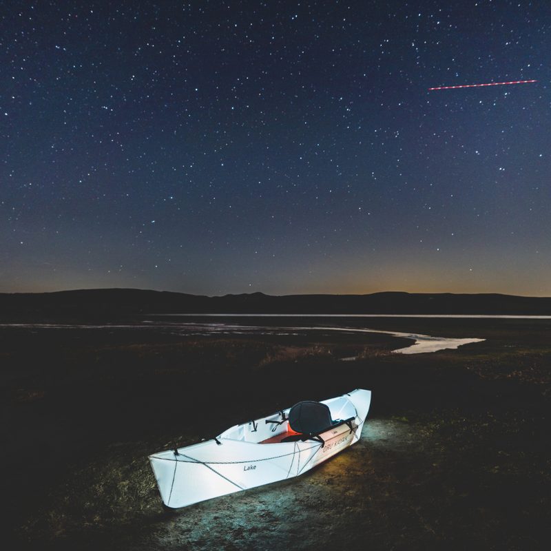 A foldable kayak at night with lights inside