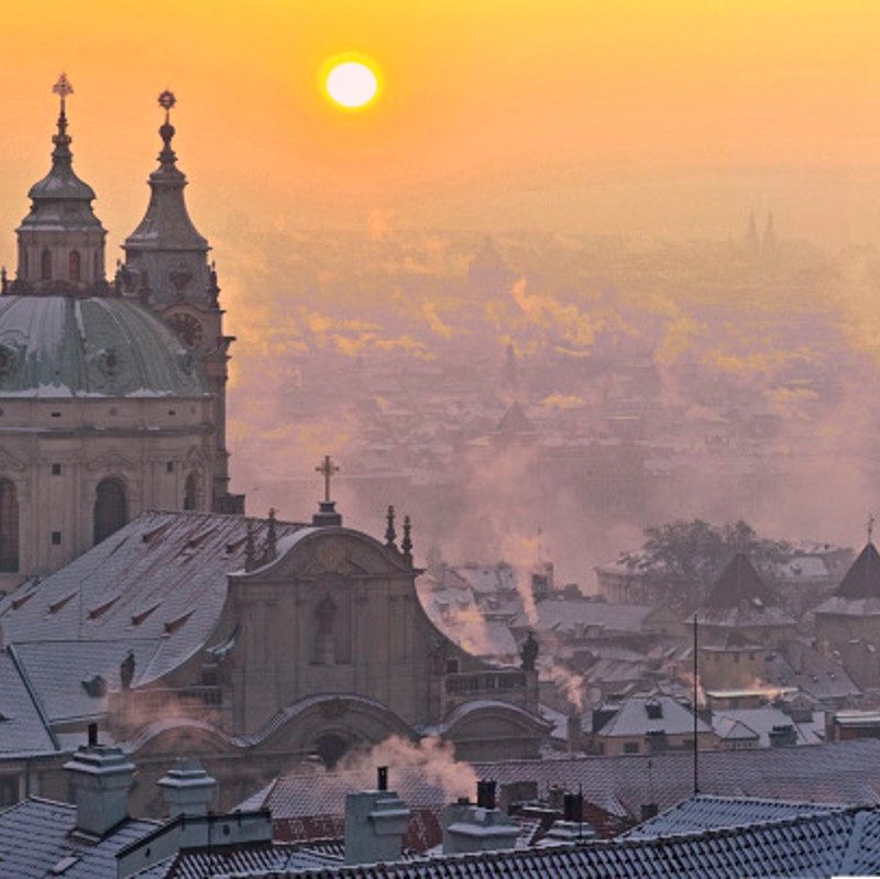A hazy sunrise over Prague's Old Town.
