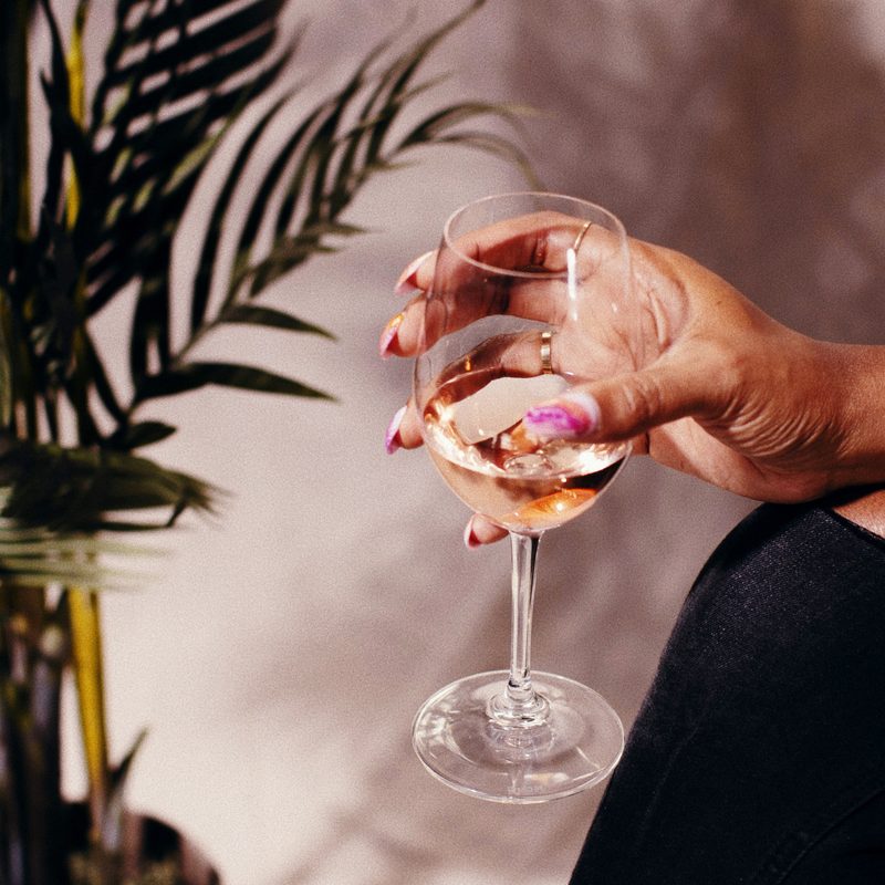 Holding a glass of rosé wine