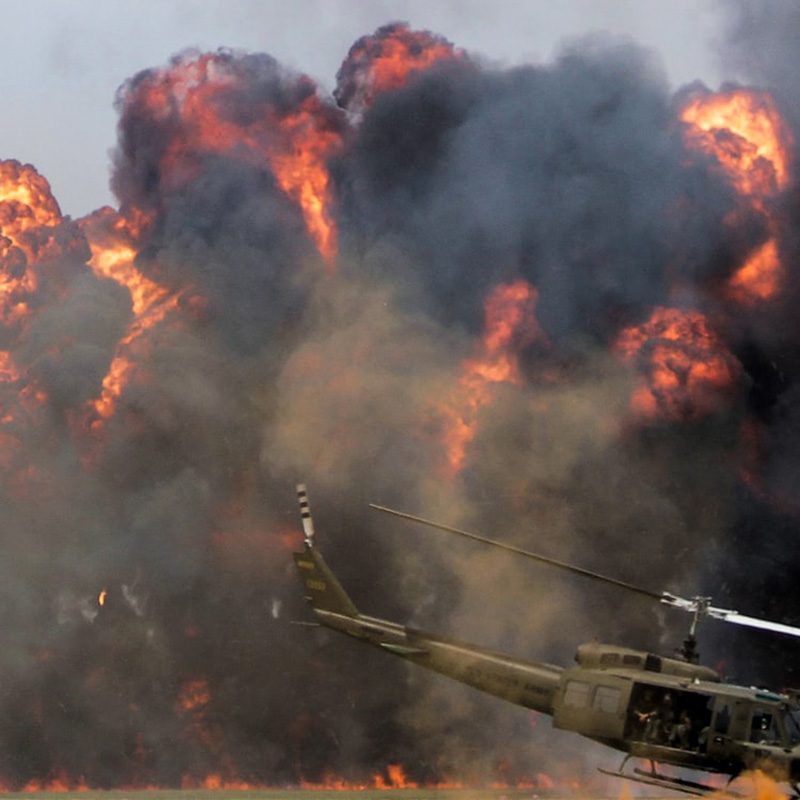 U.S. helicopter dropping bombs on a battlefield