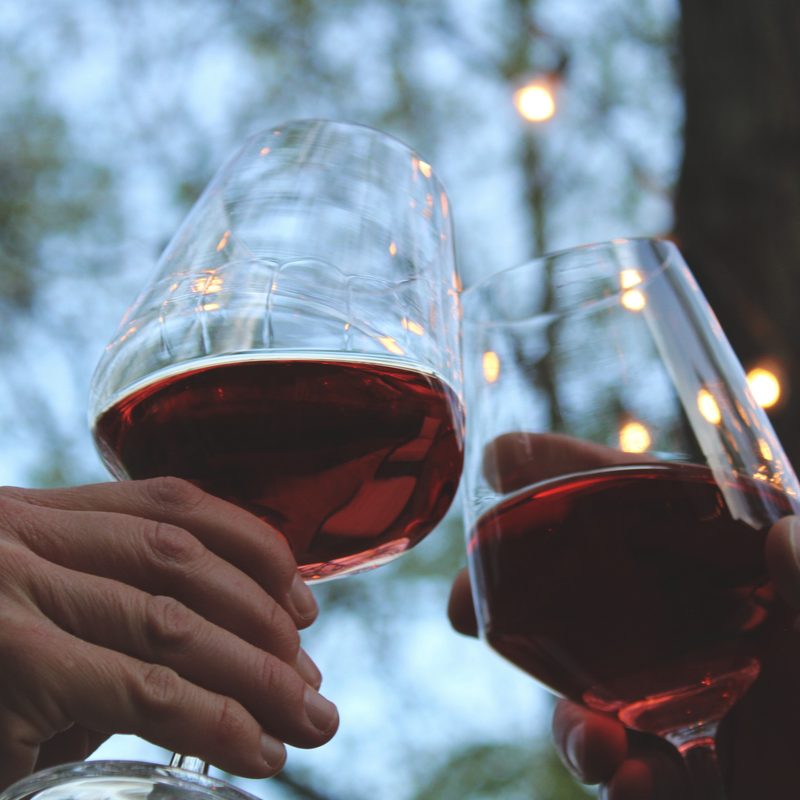 Clinking glasses of red wine