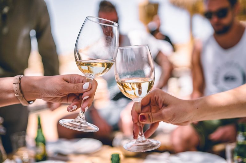 Clinking glasses of white wine