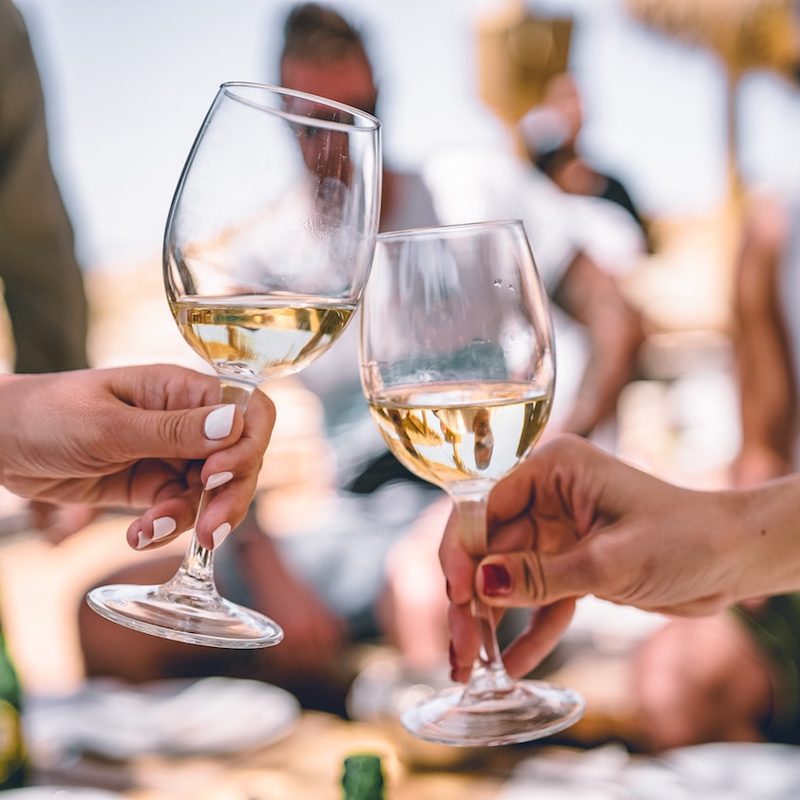 Clinking glasses of white wine