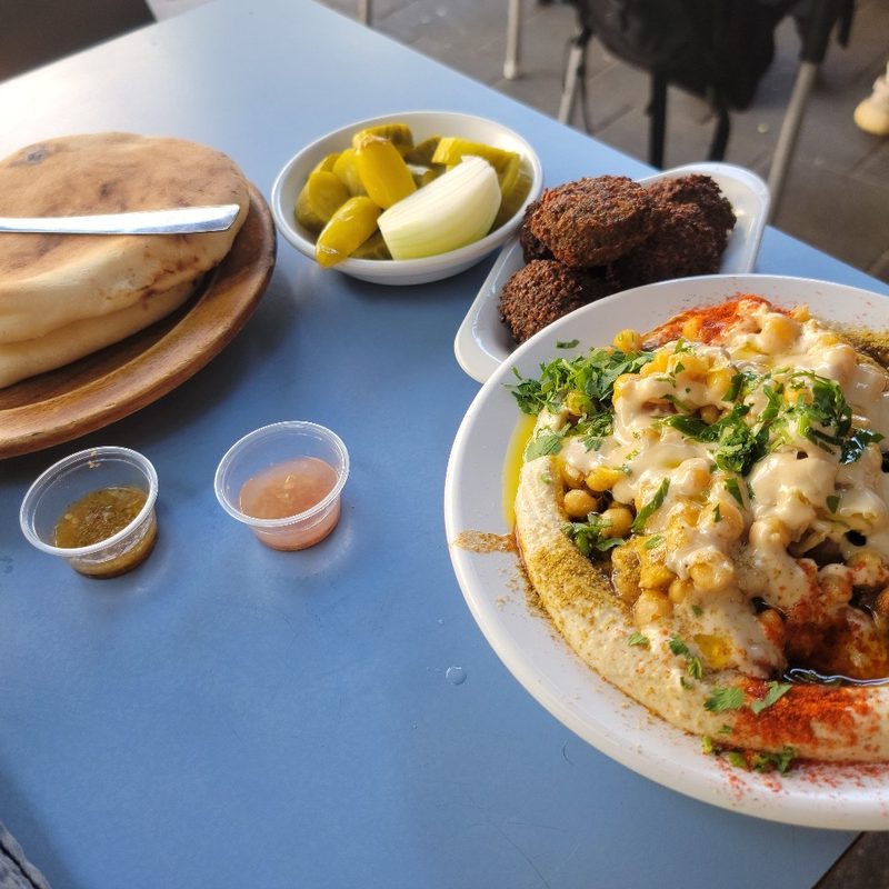 A table full of hummus, falafel, and more at Hummus Abu Dabi in Tel Aviv (Israel).