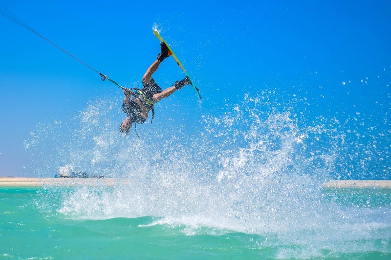 A kitesurfer flipping in the warm water at Fuwairit Kite Beach