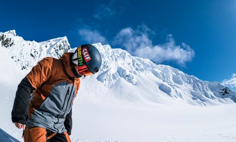 Elena Hight on a snowboard in mountainous backcountry.