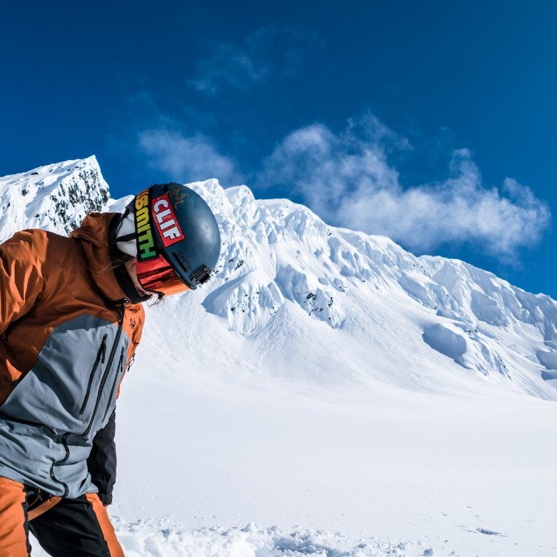 Elena Hight on a snowboard in mountainous backcountry.