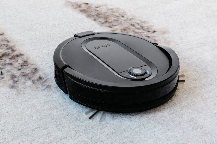 Shark IQ robot vacuum cleaning dirt on white carpet