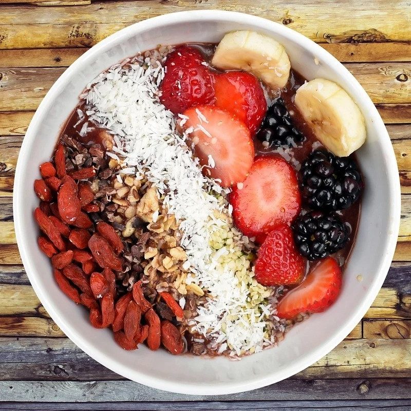 Bowl of foods high in soluble fiber with fruit and nuts and oats