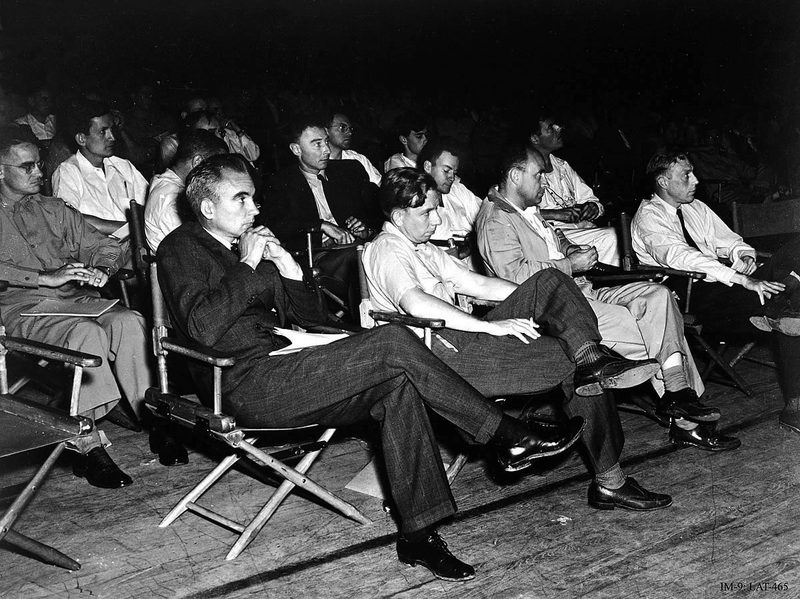 A group of physicists at the 1946 Los Alamos colloquium. J. Robert Oppenheimer sits in suit and tie in the center of the second row.