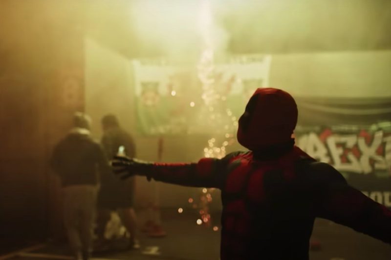 A man in a Deadpool costume celebrates Ryan Reynolds and Rob McElhenney taking over the Wrexham football team.