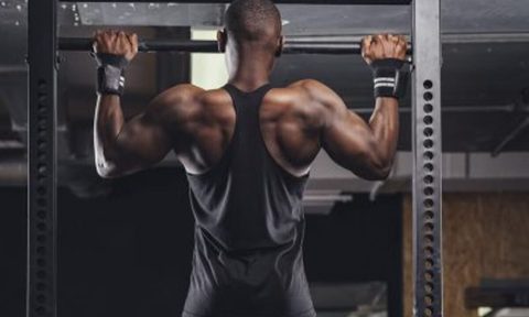 Man doing pullups in a gym.